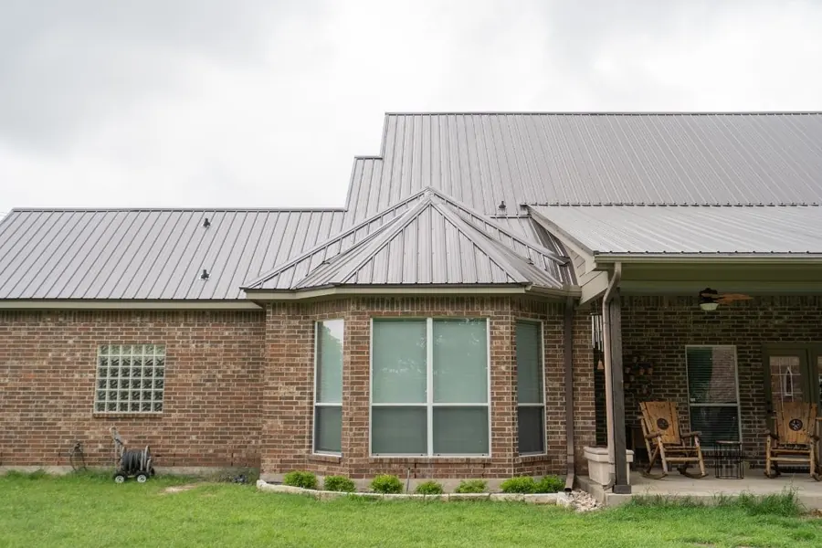Brick home with metal roof and covered porch